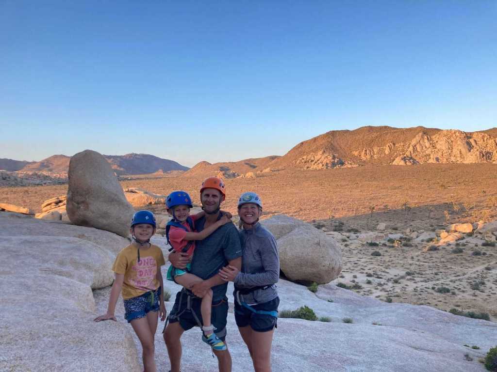 family of hikers standing on a mountain with beautiful view at the background