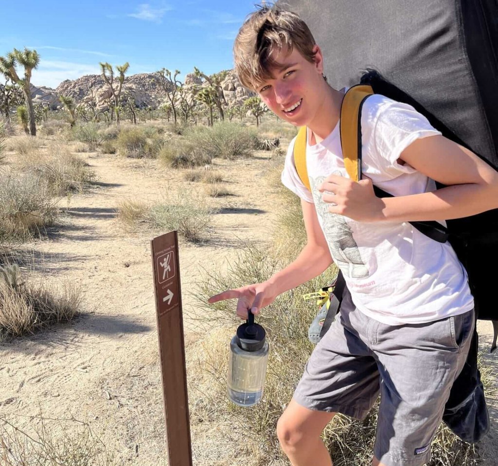 a man with a pointing to a sign
